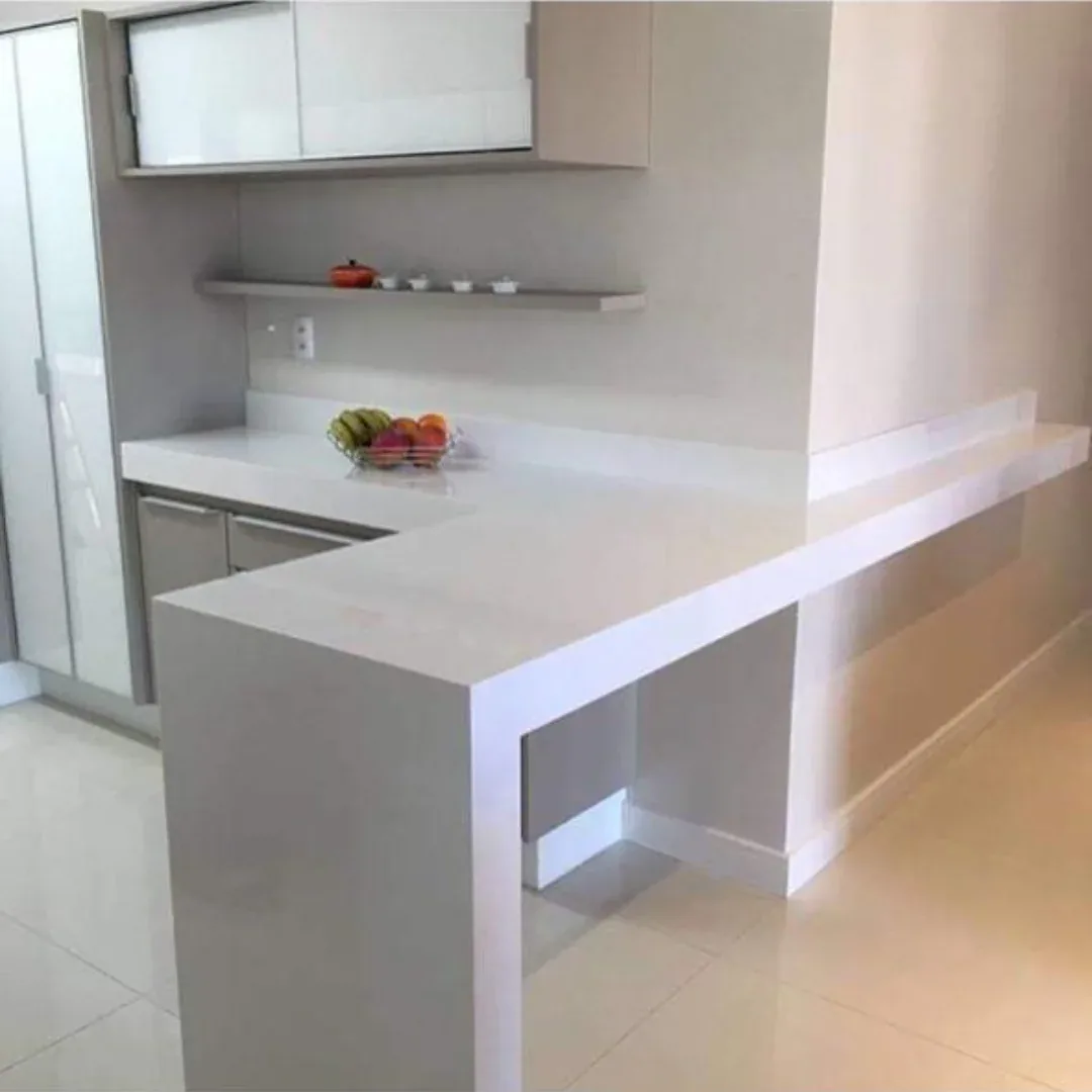 Bancada em L com superfície clara e prolongamento em balcão, obra entregue pela Marmoraria JMF