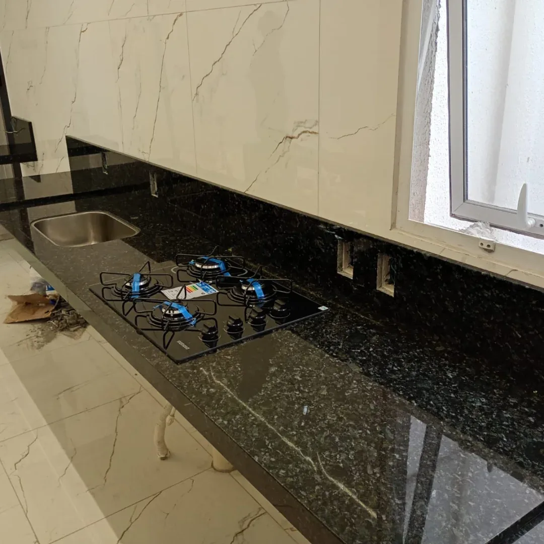 Bancada de granito escuro com cooktop e cuba instalada
