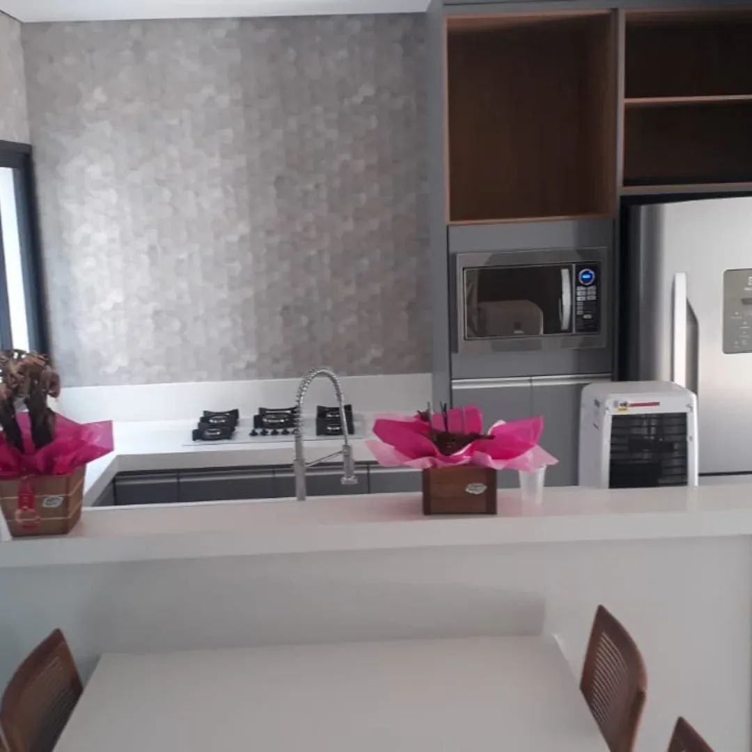 Cozinha com bancada clara e balcão de apoio finalizada