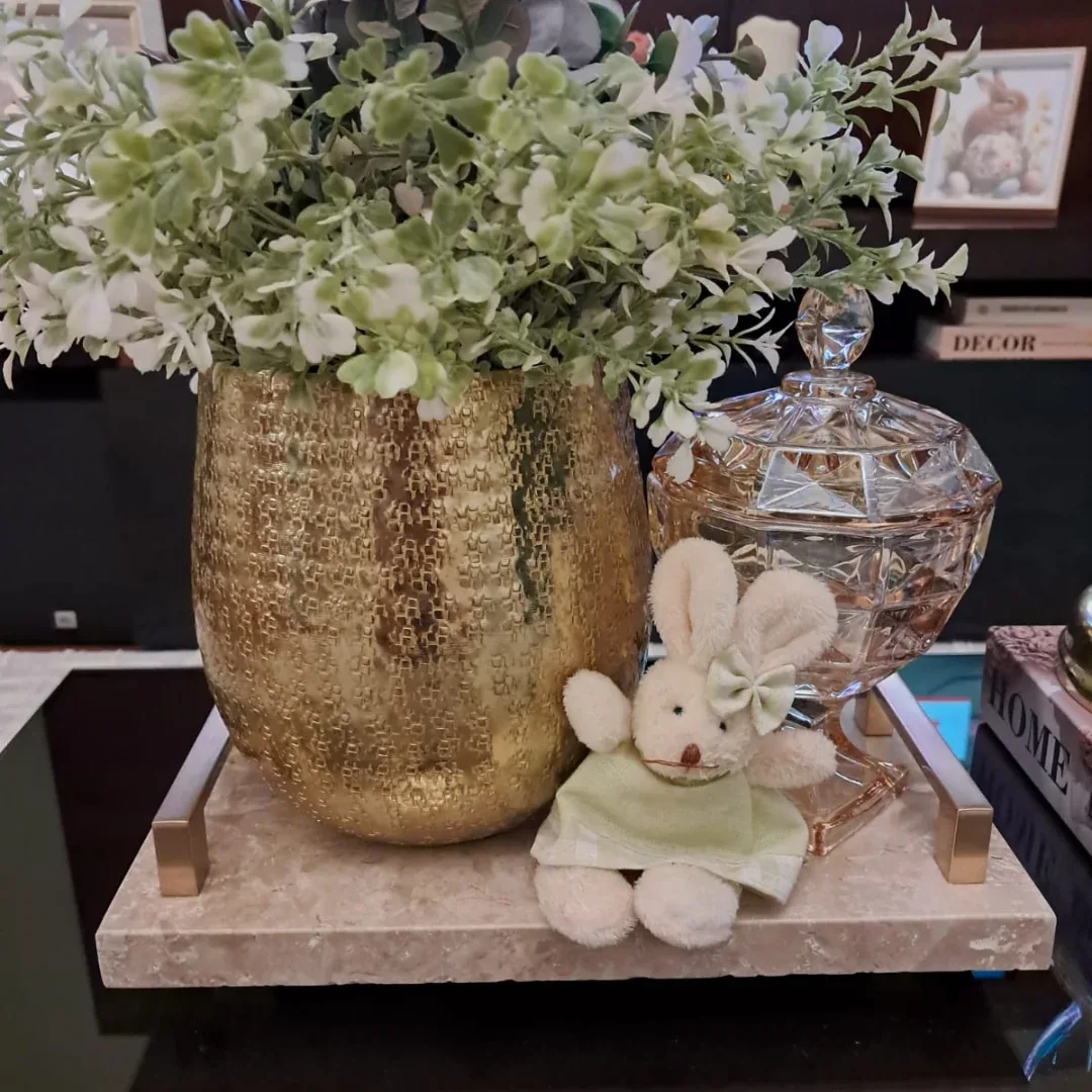 Peça redonda em pedra usada como base decorativa sobre móvel